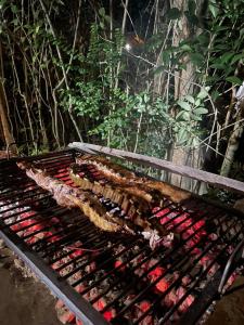 uma grelha com muitos tipos diferentes de carne sobre ele em Mostrotel - Tu Hotel en el Delta em Tigre