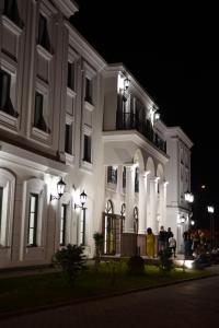 Hotel Beli Dvor في تشاتشاك: مجموعة من الناس تقف خارج المبنى في الليل
