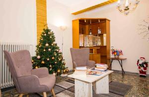uma sala de estar com uma árvore de Natal e duas cadeiras em Laconian Collection Dorieon em Sparti