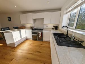 a kitchen with white cabinets and a stove top oven at Middleton in Bognor Regis