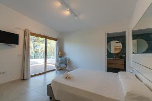 a white bedroom with a large bed and a window at THE BEACH in Olbia