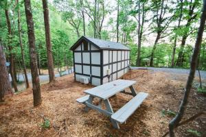 a picnic table and a play house in the woods at Tiny Home Cottage Near the Smokies #8 Helga in Sevierville +9 photos