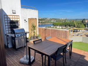a patio with a grill and a table on a balcony at Penthouse Terraço de Coimbra in Coimbra