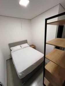 um pequeno quarto com uma cama e um espelho em Casa com piscina completa no ABC em São Bernardo do Campo
