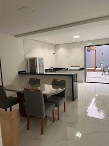 uma sala de jantar com mesa e cadeiras e uma cozinha em Casa com piscina completa no ABC em São Bernardo do Campo