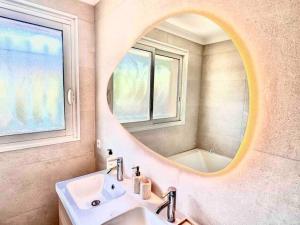 een badkamer met een wastafel en een spiegel bij Superbe 8 couchages 200m de la mer - terrasse/clim in Saint-Raphaël