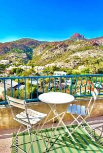 twee stoelen en een tafel op een balkon met een berg bij Superbe 8 couchages 200m de la mer - terrasse/clim in Saint-Raphaël