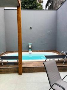 uma piscina com duas cadeiras e uma mesa em Casa com piscina completa no ABC em São Bernardo do Campo