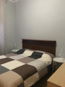 - une chambre avec un lit noir et blanc et 2 tables dans l'établissement A due passi dal mare, à Montesilvano