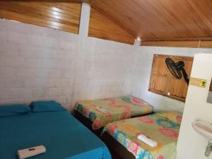 a small room with two beds and a sink at Hostal Sol de Verano Doña Lilia in Villavieja