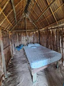 a large bed in a straw hut at Cabañas tradicionales en isla Aroma in Warsobtugua