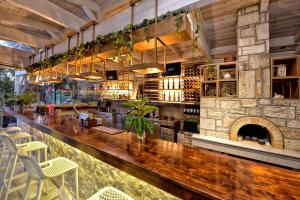 a bar in a restaurant with a stone fireplace at Georgia's Garden by Omilos Hotels in Amoudara Herakliou