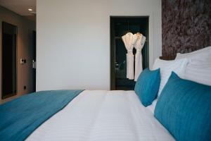 a bedroom with a large white bed with blue pillows at Sable Bleu Boutique Hotel in Le Marin