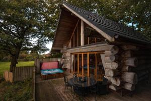 a small log cabin with a table and a patio at Alder Lodge with Hot-tub in Carlisle