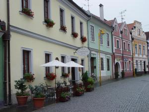 een lege straat met een paraplu en stoelen en gebouwen bij Hotel Galerie in Třeboň