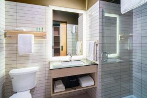 ein Badezimmer mit einem WC, einem Waschbecken und einem Spiegel in der Unterkunft Métis Crossing in Smoky Lake