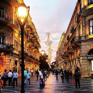 a group of people walking down a city street at View Nizami Street Chapman Taylor Baku in Baku