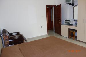 Zimmer mit einem Bett und einer Küche mit einer Mikrowelle in der Unterkunft КЪЩА"Перла" in Rawda