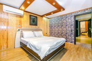 een slaapkamer met een bed in een kamer met houten wanden bij View Nizami Street Chapman Taylor Baku in Baku