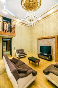 a living room with couches and a television and a chandelier at View Nizami Street Chapman Taylor Baku in Baku
