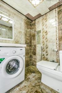 a bathroom with a washing machine and a toilet at View Nizami Street Chapman Taylor Baku in Baku