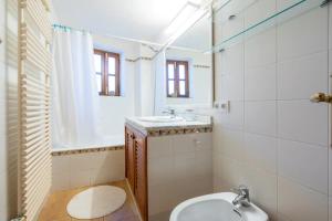 a bathroom with a sink and a toilet and a mirror at La Cubana Casa Vacacional in Banyalbufar