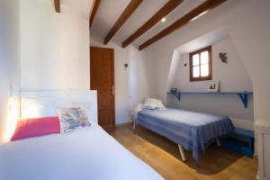 a bedroom with two beds and a window at La Cubana Casa Vacacional in Banyalbufar