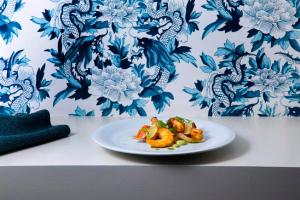 a plate of food on a table with blue and white wallpaper at Grande Real Villa Itália Hotel & Spa in Cascais