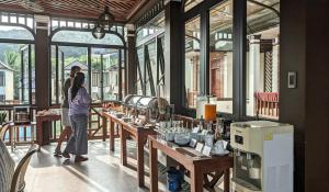 two women standing in a restaurant with tables and windows at Palm Bay Resort Phu Quoc in Phú Quốc