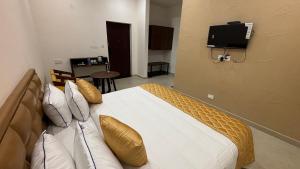 a bedroom with a bed with a television on the wall at THE RIVIERA in Theni