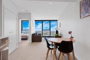 een woonkamer met een tafel en stoelen met uitzicht bij High level riverview 1B1B apt in Centre of CBD in Brisbane