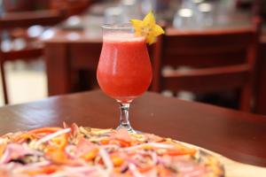 a drink with a flower on top of a pizza at Hotel La Vid La Fortuna in Fortuna