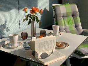 een tafel met een laptop en een vaas met bloemen bij Luxusferienwohnung-|-Koehnke-7 in Hahnenklee-Bockswiese