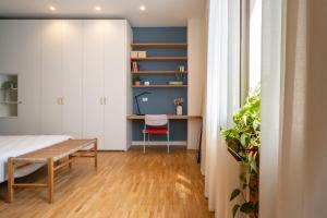 a bedroom with a bed and a desk and a chair at Realkasa Gallery Blue Suite in Bologna