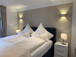 een slaapkamer met een wit bed met verlichting bij Luxusferienwohnung-|-Koehnke-7 in Hahnenklee-Bockswiese