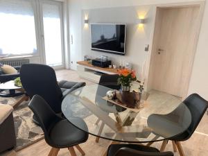 een woonkamer met een glazen tafel en stoelen bij Luxusferienwohnung-|-Koehnke-7 in Hahnenklee-Bockswiese