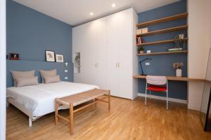 a bedroom with a bed and a desk and shelves at Realkasa Gallery Blue Suite in Bologna