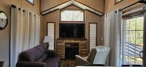 a living room with a tv and a couch and chairs at Tiny home with hammock loft BBQ and yard in Phenix City