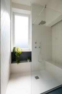 a bathroom with a shower with a window and a plant at Realkasa Gallery Blue Suite in Bologna