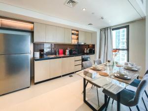 a kitchen with a table and a refrigerator at Amazing Burj and Opera View Apartment 163BC-2 in Dubai