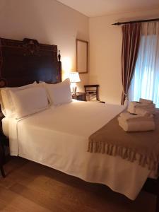 1 dormitorio con 1 cama blanca grande y toallas. en Casa Lavanda, en Évora