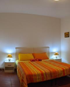 a bedroom with a large bed with two night stands at Il Verde Ulivo in Funtana Meiga