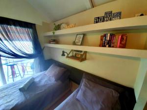 a bedroom with two beds and a book shelf at Cabana's on Gatun Lake in Arenosa in Arenosa