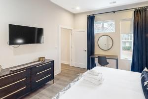 a bedroom with a bed and a tv on the wall at Country Classic at West End Living, Unit #203 in Nashville