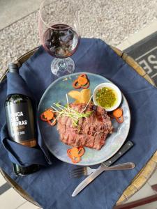 einen Teller Steak und ein Glas Wein auf dem Tisch in der Unterkunft Hotel La Vid La Fortuna in Fortuna