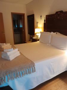 1 dormitorio con 1 cama grande con sábanas y almohadas blancas en Casa Lavanda, en Évora
