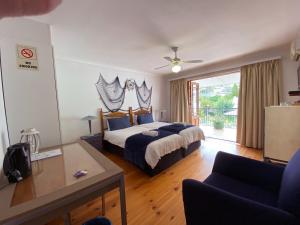 a hotel room with a bed and a balcony at Le Bay Lodge in Gordonʼs Bay