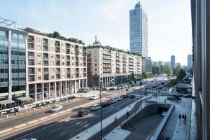 uma vista para uma rua da cidade com carros e edifícios em Vittore Rooms & Apartment em Milão