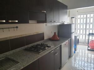 a kitchen with a stove and a refrigerator at APPARTEMENT sofia Haymohameddi in Agadir