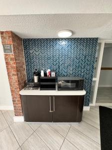 a kitchen with a counter top and a blue wall at Studio 6 Suites East Syracuse NY Airport in East Syracuse